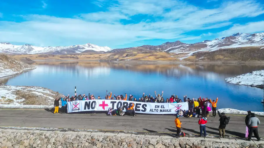 Comunidad reunida en la Laguna del Maule con el lienzo No + Torres en el Alto Maule